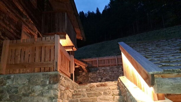 Eine Holztreppe mit Steinstufen, die zu einem Holzhaus führt.