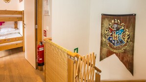 A room with a bunk bed, a fire extinguisher, a wooden railing, and a banner with a crest. - Duplex Apartment Near the Center (Middelkerke)