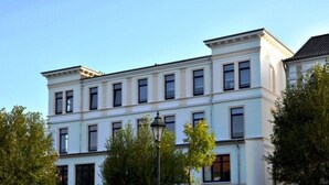 A multi-story building with a classical architectural style, featuring a symmetrical facade with evenly spaced windows and a central entrance. - Siam Comfortable Holiday Residence (Borkum)