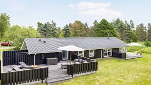 A two-story house with a deck, outdoor seating, and a car parked nearby. - 7 Person Holiday Home in Jerup (Jerup)