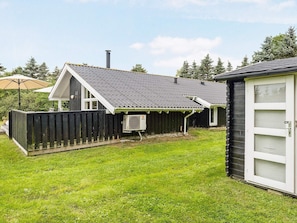 A house with a fenced backyard, a chimney, and a covered porch. - 7 Person Holiday Home in Jerup (Jerup)