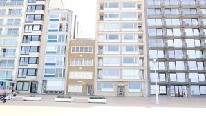 A multi-story hotel with balconies, a central entrance, and a parking area. - Apartment in Nieuwpoort by the Beach (Nieuwpoort)