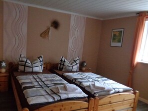 A bedroom with two wooden beds, each with a striped blanket and matching pillows. - Fantastic Apartment in Reinhardshagen (Reinhardshagen)