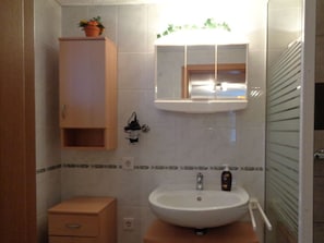 A bathroom with a wooden cabinet, a sink, and a mirror. - Fantastic Apartment in Reinhardshagen (Reinhardshagen)
