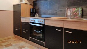 A compact kitchen with a stove, oven, and a coffee maker on the countertop. - Fantastic Apartment in Reinhardshagen (Reinhardshagen)