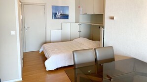 A bedroom with a bed, a glass table, a chair, a wardrobe, and a picture on the wall. - Apartment in Nieuwpoort Near Sandy Beaches (Nieuwpoort)