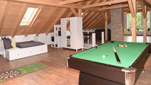 A spacious attic room with a pool table, a cozy seating area, and a large window providing natural light. - Lovely Apartment in Himmelkron (Himmelkron)