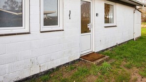 A white building with a door, windows, and a small porch. - 3 Person Holiday Home in Sydals (Sydals)
