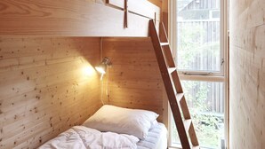 A compact wooden cabin room with bunk beds, a ladder, and a window providing a view of the outside. - 8 Person Holiday Home in Sondeled (Risør)