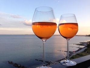 Deux verres à vin, avec une vue sur le coucher de soleil au-dessus de la mer.