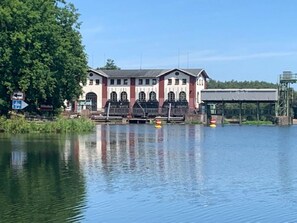 Un bâtiment doté d’une grande porte d’écluse et d’un pont enjambant une rivière.