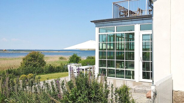 A modern building with large windows overlooking a body of water. - 5 Star Holiday Home in Assens (Assens)