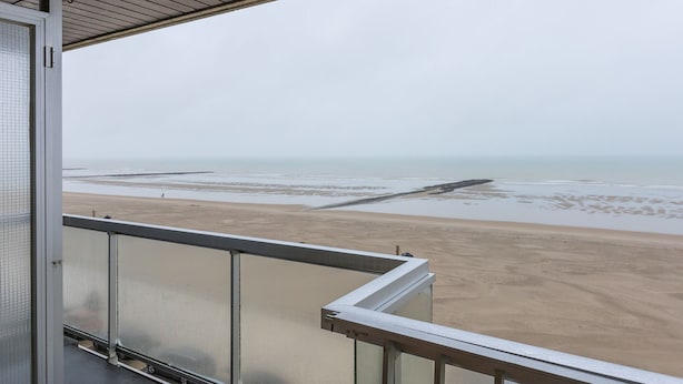 Ein Balkon mit Blick auf einen Strand und das Meer.