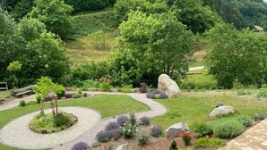 A landscaped garden with a winding gravel path, various shrubs, and large rocks. - Lovely Apartment in Baden-wurttemberg (Oberkirch)