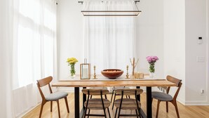 A dining area with a wooden table, six chairs, and a large bowl centerpiece.