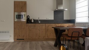 Een moderne keuken met houten kastjes, een ingebouwde magnetron en een rvs afzuigkap.