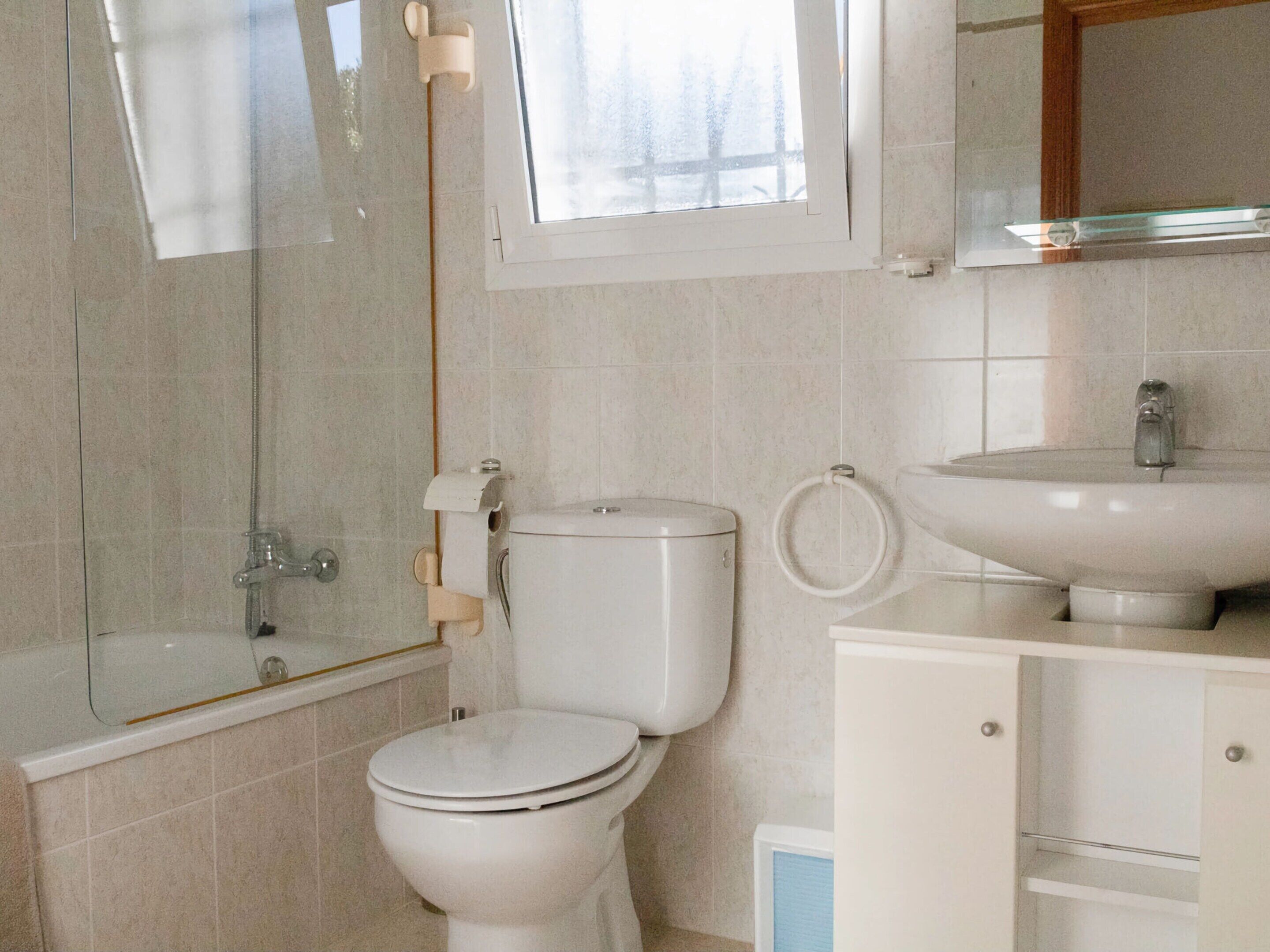 Une salle de bain avec des toilettes, un lavabo et une baignoire.