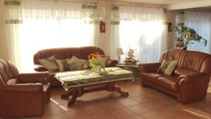 Una sala de estar con dos sofás de cuero, una mesa de centro de madera y una planta en maceta.