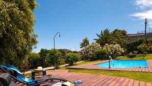 A wooden deck with lounge chairs and a swimming pool. - Villa in Gran Canaria With Private Pool & Tennis (Arucas)