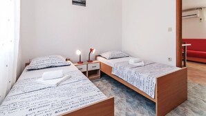 A small, clean room with two beds, a nightstand, and a small table. - Apartments Hak - One Bedroom Apartment With Terrace and Sea View (Vir)