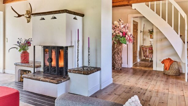 A cozy room with a stone fireplace, a wooden ceiling, and a staircase. - Appelhus Modern Retreat (Loit)