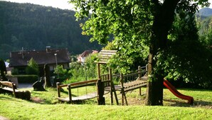 A playground with a slide and a wooden bench. - Haus Edith Modern Retreat (Lug)