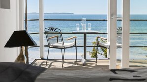 Een balkon met een tafel, stoelen en een lamp.