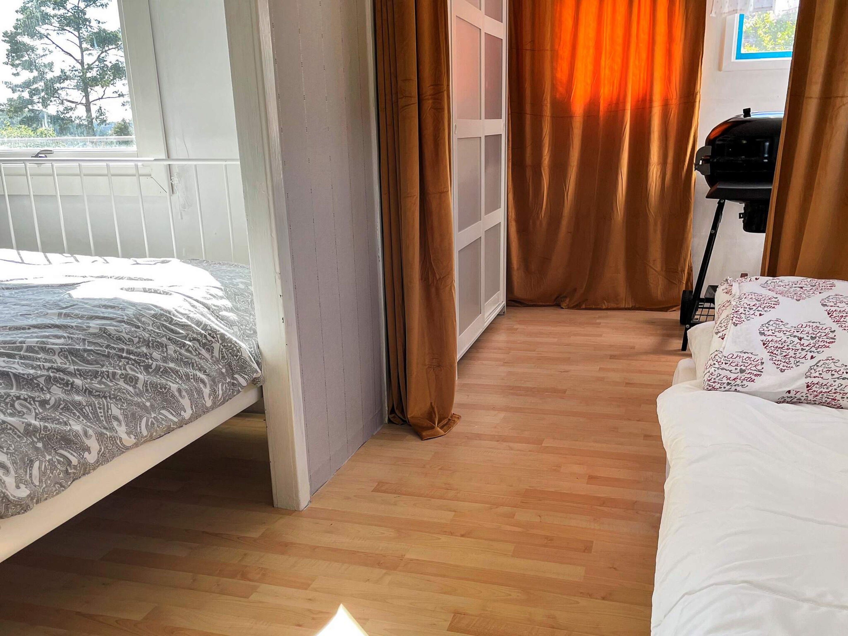Quarto com cama, janela, porta e grades.