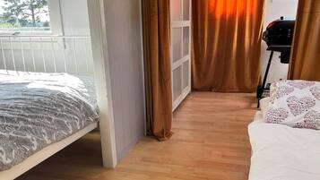 Quarto com cama, janela, porta e grades.