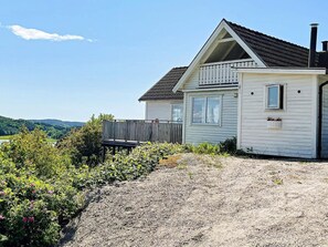 A single-story house with a balcony, a wooden deck, and a view of the landscape. - 4 Star Holiday Home in Uddevalla (Uddevalla)