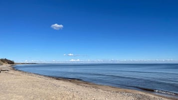 Una playa con cielos despejados y agua tranquila.
