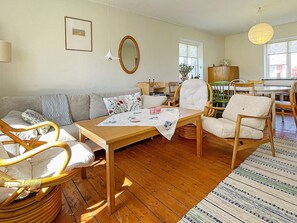 Un salon chaleureux avec une table en bois, des chaises, un canapé et un coin repas.