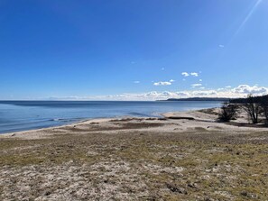 A coastal landscape with a sandy beach, a clear sky, and a distant shoreline. - 5 Person Holiday Home in Brosarp (Brosarp)
