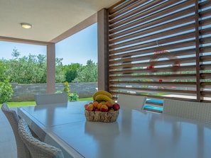A dining area with a table, chairs, and a fruit basket. - Villa Stefanja Comfortable Holiday Residence (Vodnjan)