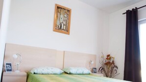 A bedroom with a bed, nightstands, a framed artwork, and a window with curtains. - Apartments Paula - One Bedroom Apartment With Terrace 1 (Tisno)