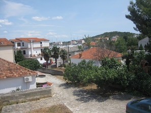 Un quartier résidentiel avec des maisons, une route asphaltée et, au loin, un port de plaisance.