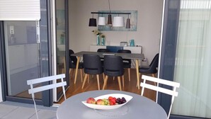 Un comedor moderno con una mesa redonda, dos sillas, un frutero y una mesa de comedor con sillas.