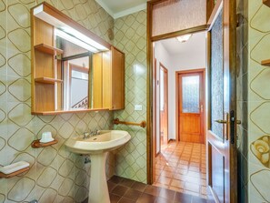 A bathroom with a sink, mirror, and wooden cabinets. - Spacious Holiday Home in Marciaga With Garden (Costermano sul Garda)