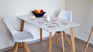 A small dining table with a floral tablecloth, a fruit basket, and a candle. - Palatinate Forest Comfortable Holiday Residence (Silz)