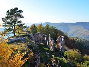 A historical site with ruins and a large tree, surrounded by autumn foliage and hills. - Palatinate Forest Comfortable Holiday Residence (Silz)