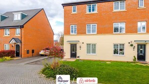 A residential building with a brick facade, multiple windows, and a well-maintained lawn. - Spacious 5BR Chester | Group & Contractor Stays (Cheshire West and Chester)