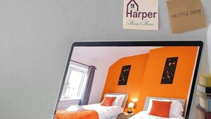 A laptop displaying a hotel room with two beds, a nightstand, and a window. - Spacious 5BR Chester | Group & Contractor Stays (Cheshire West and Chester)