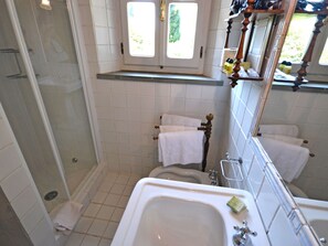 A bathroom with a shower, toilet, and bathtub. There are two windows above the toilet, and a towel rack is visible. - Belvilla by OYO Villa Vittoria (Cortona)
