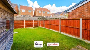 A residential area with a fenced backyard, brick houses, and logos for Harper Home and Airbnb. - Cosy 3BR Deeside Sleeps 5 | Contractor Stays (Flintshire)