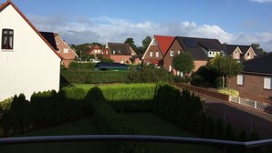 A residential area with houses, a green lawn, and a clear sky. - Holiday Apartment Susewind (Borkum)