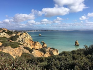 Un paysage côtier caractérisé par un terrain rocheux et des eaux d’un bleu limpide.