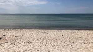 A beach with a sandy shore and calm sea under a clear sky. - 3 bedroom nice home in Store Fuglede (Store Fuglede)