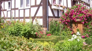 A Tudor-style building with a garden in front. - Werts HOF Holiday Home (Rauschenberg)