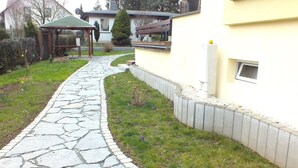 A stone pathway leading to a wooden gazebo in a residential area. - Holiday Home in Lichtenau With Garden Bliss (Lichtenau)