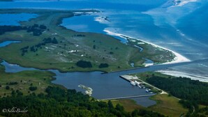 An aerial view of a coastal area with a marina, green fields, and a large body of water. - Holiday Apartment Lutt Matten (Zingst)